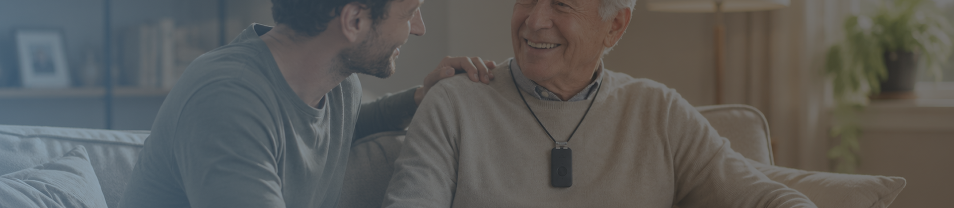 A caregiver and an older man sharing a warm moment at home, the man wearing a Medical Life Club alert pendant